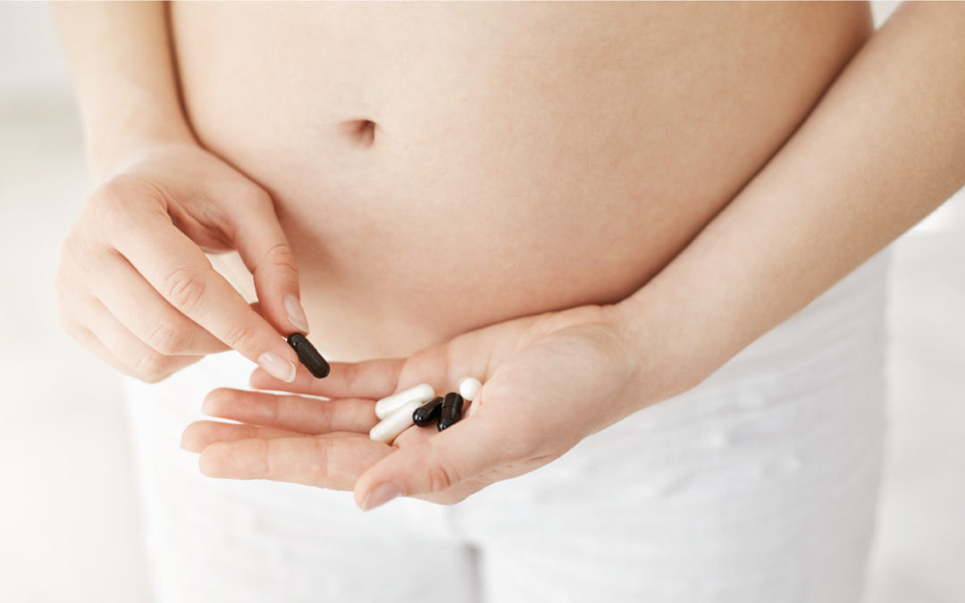 zwangere vrouw met melatoninepillen in haar handen