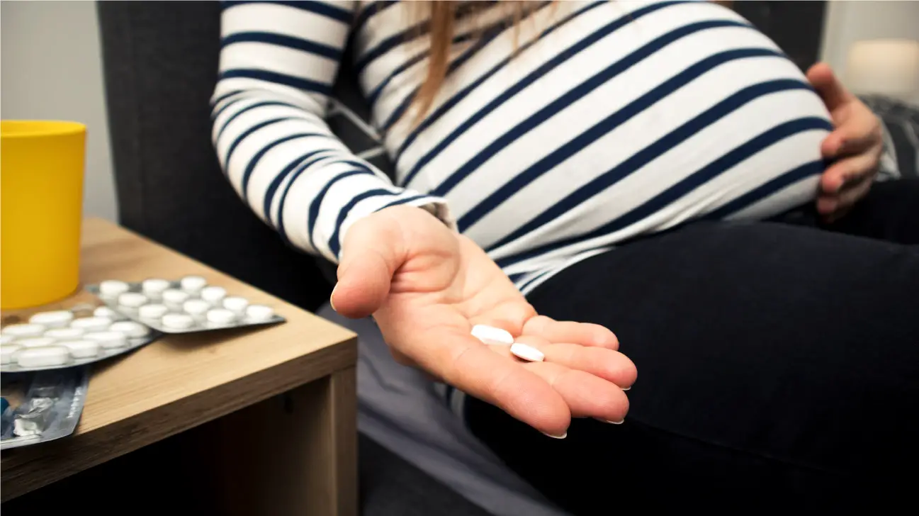 zwangere vrouw met pillen in hand