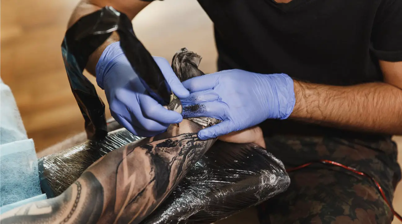 tattoeage artiest zet tattoo op onderarm