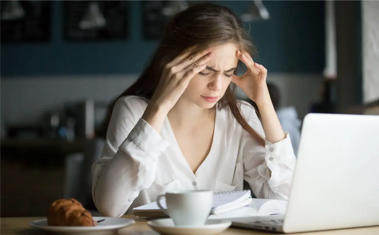 vrouw last van hoofdpijn tijdens studeren