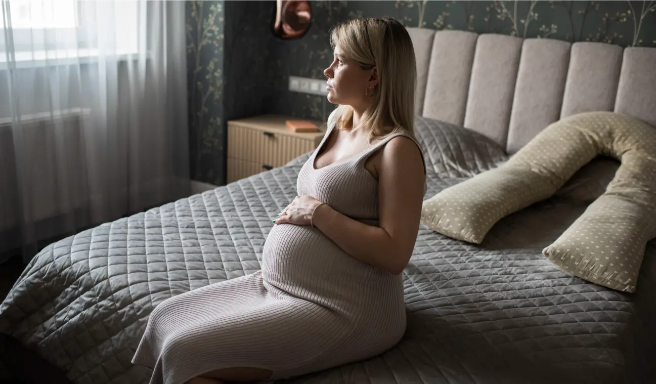 zwangere vrouw zit op bed