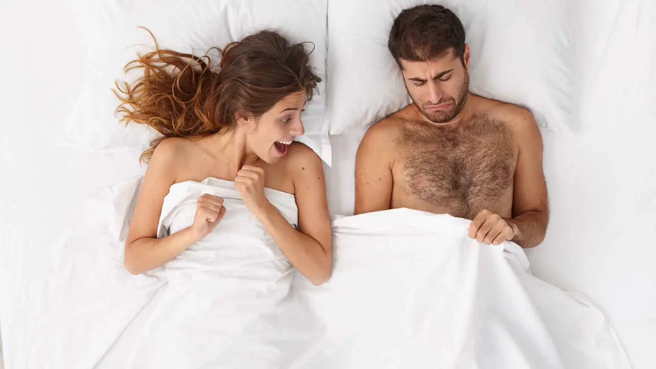 man en vrouw kijken onder de deken en vrouw is verrast