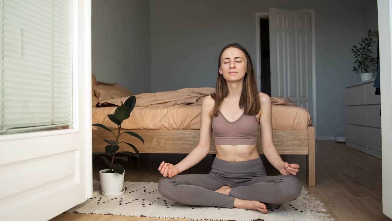 vrouw mediteert in slaapkamer