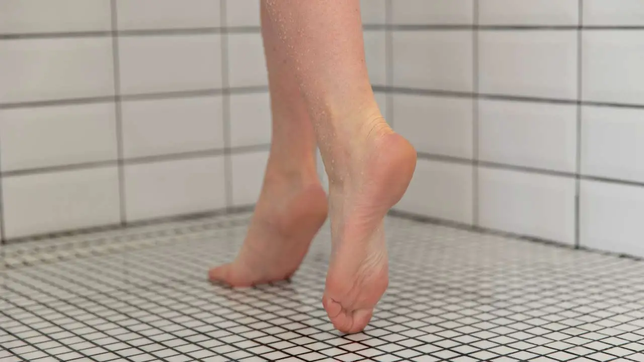 voeten van vrouw stapt in de douche