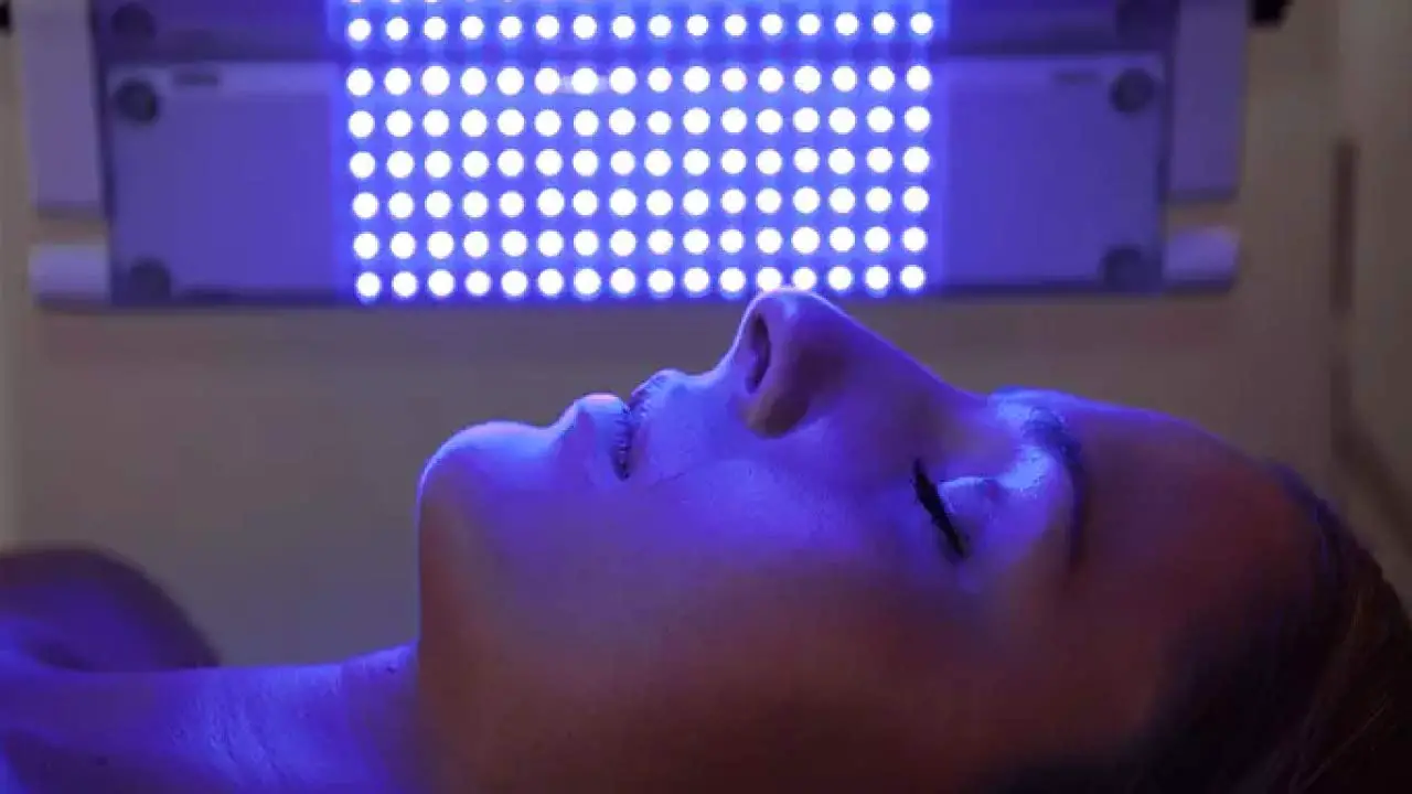 gezicht van vrouw tijdens blauwlichttherapie