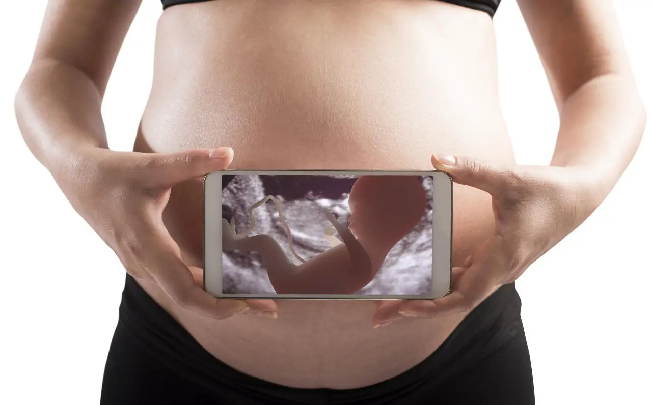 zwangere met telefoon foto baby