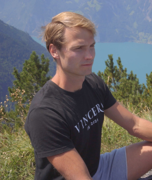 Een zittende man beoefent Buteyko-Ademhaling op een zwitserse berg in zijn Vincera shirt