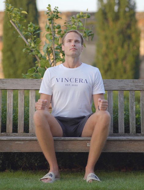 Een zittende man, buiten in zijn Vincera shirt, voert de Wim Hof Ademhaling uit