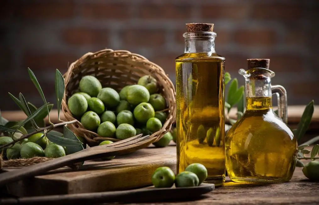 olijven in mand en olijfoliefles op houten tafel