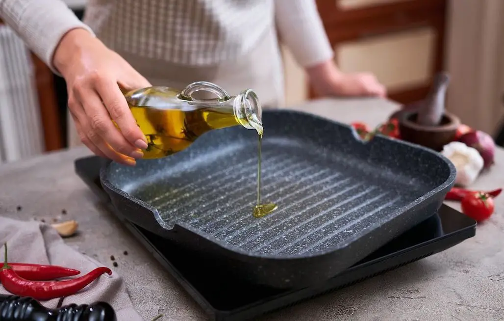 vrouw giet olijfolie over bakplaat