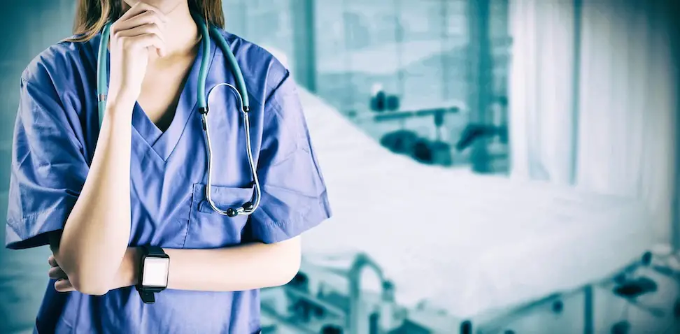 vrouwelijke dokter bij ziekenhuis bed denkt na over angstcultuur in de zorg