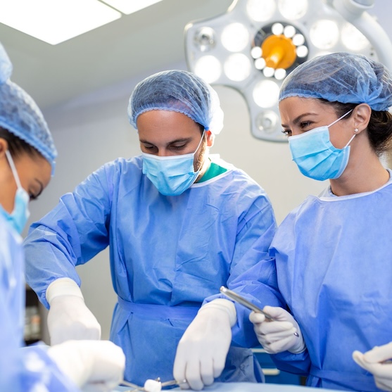 chirurg voert operatie uit met twee operatieassistenten