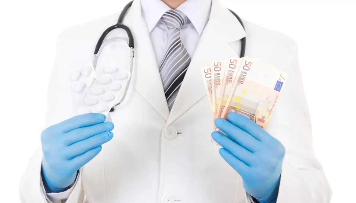 dokter in witte jas met stethoscoop houdt geld vast