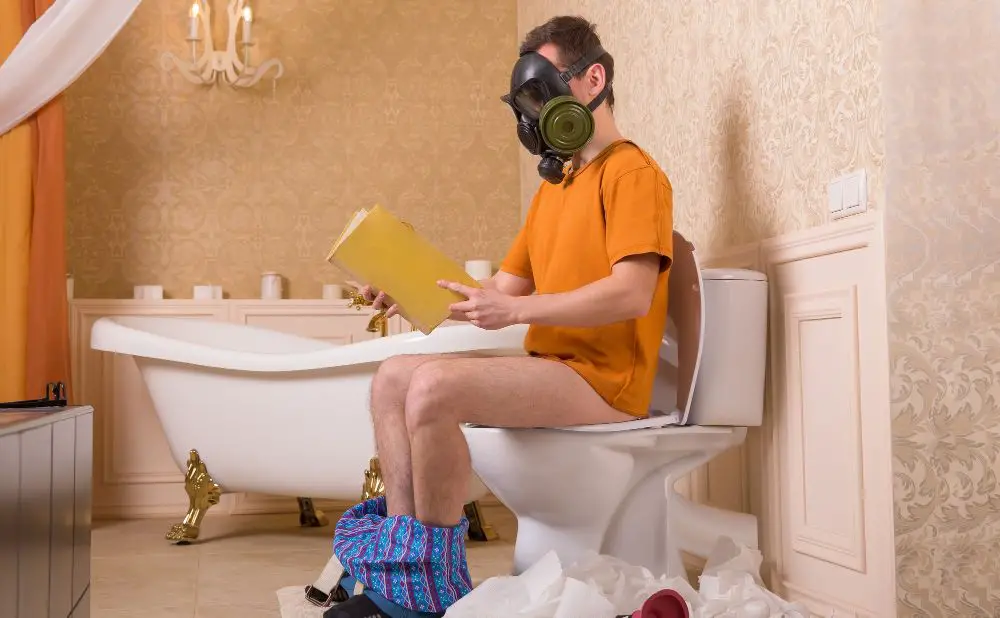 man poept op het toilet met een gasmasker op