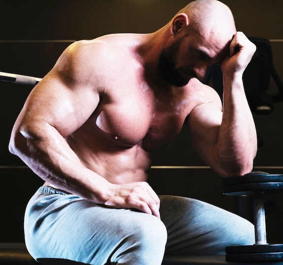 mannelijke bodybuilder zit en denkt na
