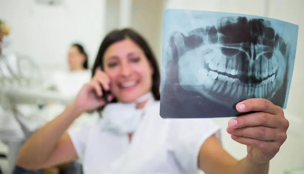 vrouwelijke tandarts houdt rontgenfoto vast